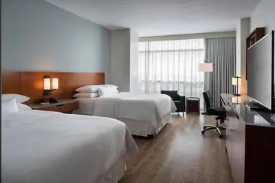 a hotel room with two beds and a flat screen tv at The Westin Lake Mary, Orlando North in Lake Mary