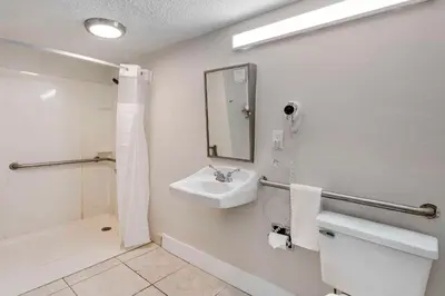 a bathroom with a sink and a toilet and a mirror at Quality Inn & Suites Orlando East - UCF Area in Orlando