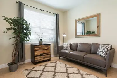 a living room with a couch and a mirror at Luxury Disney Dreams Home with Pool, Spa & Game Room in Orlando
