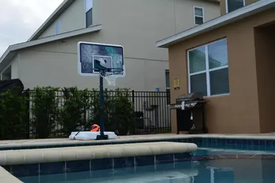 a basketball hoop next to a swimming pool at Luxury Disney Dreams Home with Pool, Spa & Game Room in Orlando