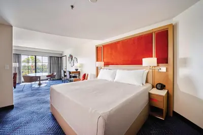 a hotel room with a large bed and a living room at Universal's Hard Rock Hotel® in Orlando