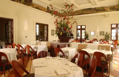 a restaurant with white tables and chairs and flowers at Universal's Loews Portofino Bay Hotel in Orlando