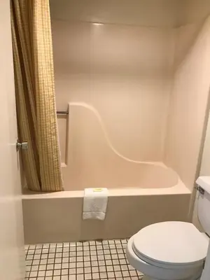 a bathroom with a toilet and a bath tub at Flamingo Inn in Kissimmee