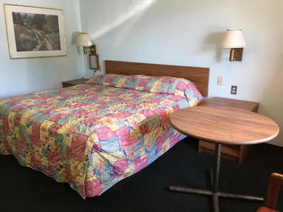 a hotel room with a bed and a wooden table at Flamingo Inn in Kissimmee