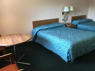 a hotel room with two beds and a table at Flamingo Inn in Kissimmee