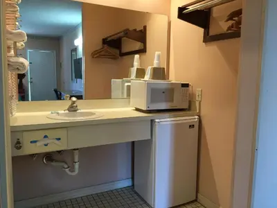 a bathroom with a sink and a microwave at Flamingo Inn in Kissimmee