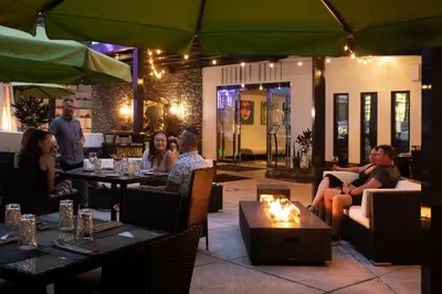 a group of people sitting around a fire in a restaurant at The Delaney Hotel in Orlando