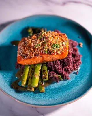 a blue plate with a piece of salmon and asparagus at The Delaney Hotel in Orlando