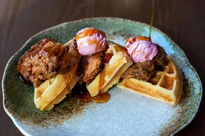 a plate of waffles with meatballs and ice cream at The Delaney Hotel in Orlando