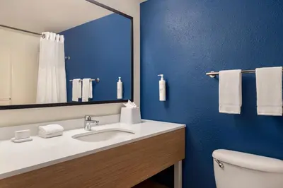 a bathroom with a sink and a mirror and a toilet at Spark by Hilton Orlando Universal Boulevard in Orlando