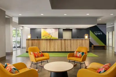 a lobby with chairs and a table and a waiting room at Spark by Hilton Orlando Universal Boulevard in Orlando