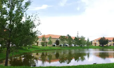 a lake in front of a building at Four Bedrooms Townhome 5126K in Kissimmee