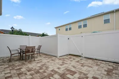 a white fence with chairs and a table on a patio at Four Bedrooms Townhouse 5102 in Kissimmee