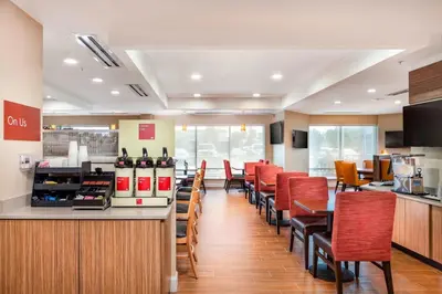 a restaurant with red chairs and a counter and a bar at TownePlace Suites by Marriott Orlando Altamonte Springs/Maitland in Orlando
