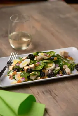 a plate of salad on a table with a glass of wine at Hyatt Place Lake Mary/Orlando North in Lake Mary