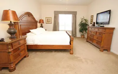 a bedroom with a bed and a dresser and a television at Shoreway House #231533 in Orlando