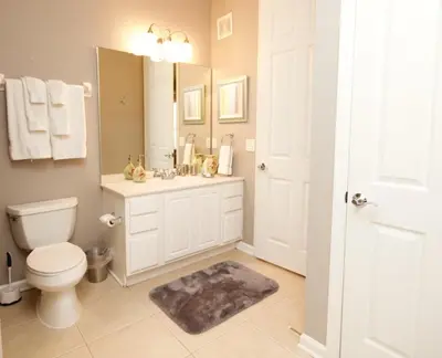 a bathroom with a toilet and a sink and a mirror at Cayview Condo #231536 in Orlando