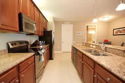 a kitchen with wooden cabinets and a black refrigerator at Cayview Condo #231536 in Orlando