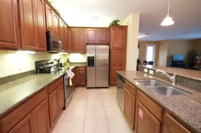 a kitchen with wooden cabinets and a stainless steel refrigerator at Cayview House #231539 in Orlando