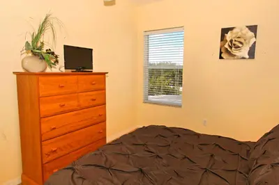 a bedroom with a bed and a dresser and a window at Morningstar Villa #230785 in Orlando