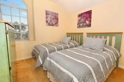 two beds in a room with a window at Morningstar Villa #230785 in Orlando