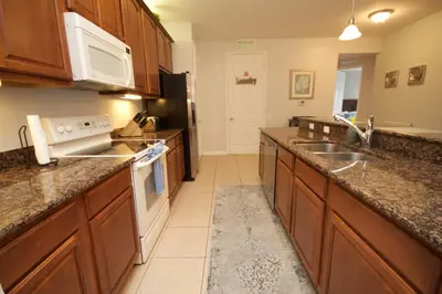 a kitchen with wooden cabinets and a counter top at Shoreway Condo #231521 in Orlando