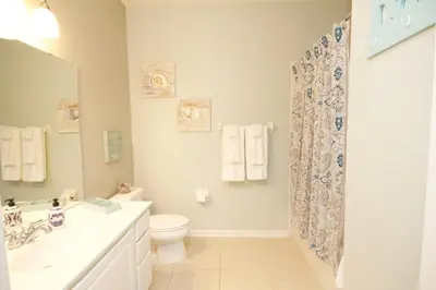 a white bathroom with a toilet and a sink at Shoreway House #231523 in Orlando