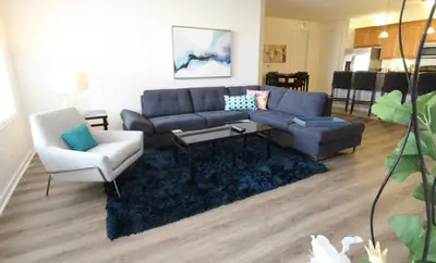 a living room with a blue couch and a chair at Shoreway Condo #231531 in Orlando
