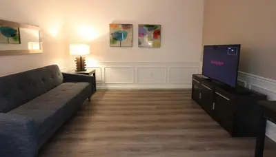 a living room with a couch and a flat screen tv at Shoreway Condo #231531 in Orlando
