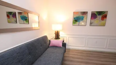 a living room with a couch and paintings on the wall at Shoreway Condo #231531 in Orlando