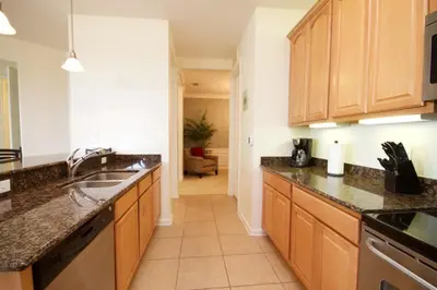 a kitchen with wooden cabinets and a sink at Shoreway Condo #231524 in Orlando