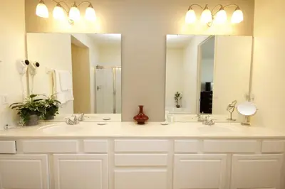a bathroom with two sinks and two mirrors at Shoreway Condo #231524 in Orlando