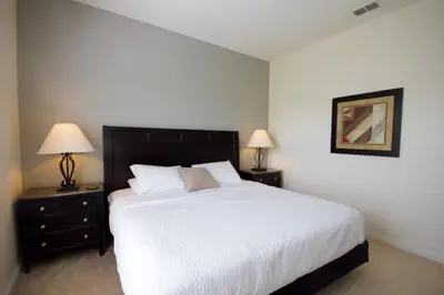 a bedroom with a large white bed with two night stands at Shoreway Condo #231524 in Orlando