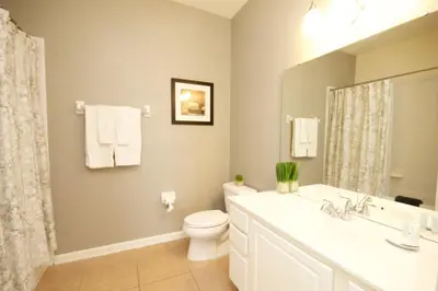 a white bathroom with a toilet and a sink at Shoreway Condo #231524 in Orlando