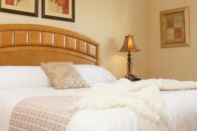 a bed with a white comforter and a lamp on a table at CayView Condo #231544 in Orlando