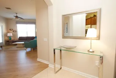 a living room with a glass table and a mirror at CayView Condo #231544 in Orlando
