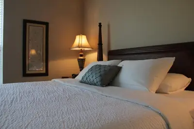 a bedroom with a large white bed with a lamp at Shoreway Condo #231520 in Orlando
