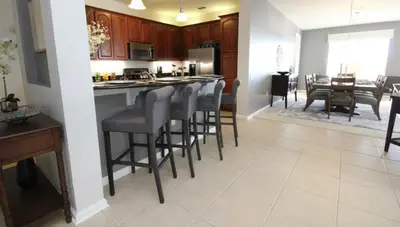 a kitchen and dining room with a bar with stools at Cayview Condo #231541 in Orlando