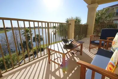 a balcony with chairs and a table with a view of the water at Cayview Condo #231541 in Orlando