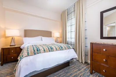 a bedroom with a bed and a dresser and a window at Marriott's Cypress Harbour Villas in Orlando