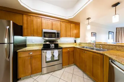 a kitchen with wooden cabinets and stainless steel appliances at Marriott's Cypress Harbour Villas in Orlando