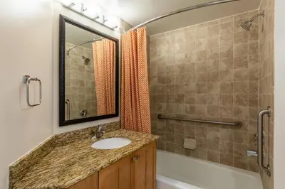 a bathroom with a sink and a shower and a mirror at Marriott's Cypress Harbour Villas in Orlando