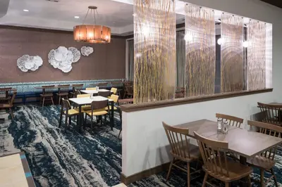 a restaurant with tables and chairs in a room at Fairfield Inn Suites by Marriott Orlando At SeaWorld in Orlando