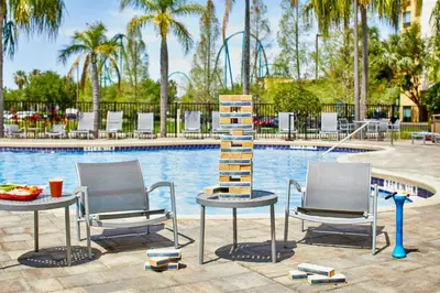 two chairs and a table in front of a pool at Fairfield Inn Suites by Marriott Orlando At SeaWorld in Orlando