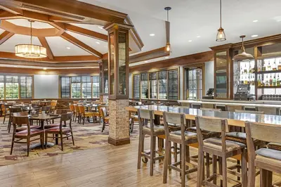 a restaurant with tables and chairs and a bar at Marriott's Grande Vista in Orlando