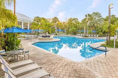 a pool at a resort with chairs and umbrellas at Marriott's Royal Palms in Orlando