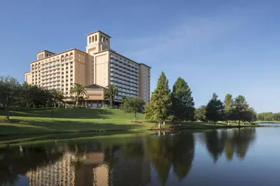 a large building with a reflection in a lake at The Ritz-Carlton Orlando, Grande Lakes in Orlando