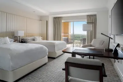 a hotel room with two beds and a desk at The Ritz-Carlton Orlando, Grande Lakes in Orlando