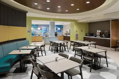 a restaurant with tables and chairs and a kitchen at SpringHill Suites by Marriott Orlando at SeaWorld in Orlando