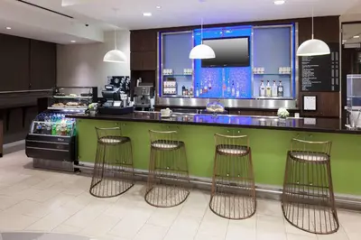 a kitchen with a green counter and bar with stools at SpringHill Suites by Marriott Orlando at SeaWorld in Orlando
